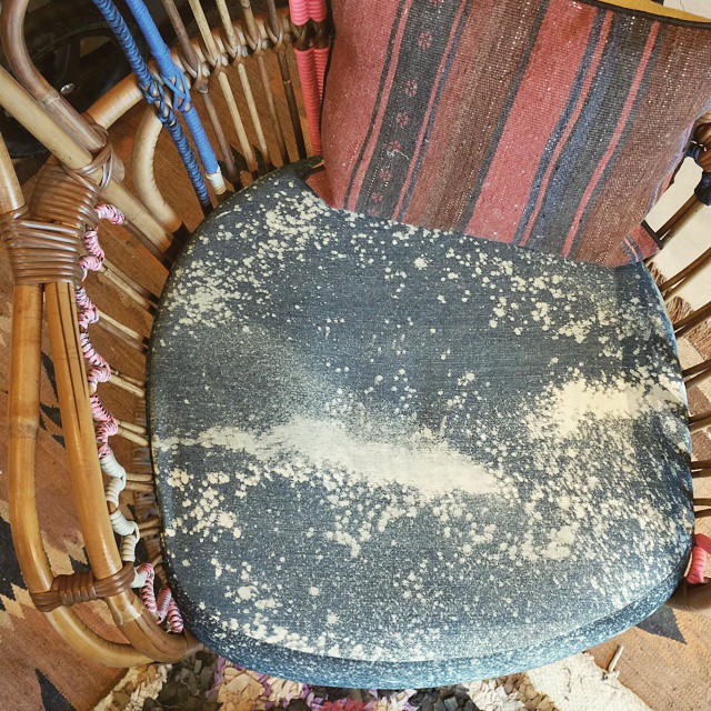 More_hippie_vibe_ideas_from_my_jaunt_around_the_Malibu_country_mart._Color_bombed_rattan_with_a_bleachy_denim_seat_cover_and_a_kilim_pillow.__intoit